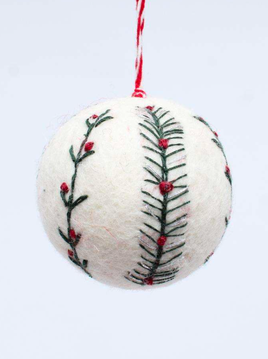 White felt Christmas bauble decorated with green evergreen sprigs and small red berries, with a red-and-white hanging loop
